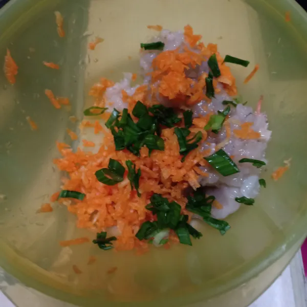 Parut wortel lalu masukkan dalam wadah berisi udang dan irisan daun bawang
