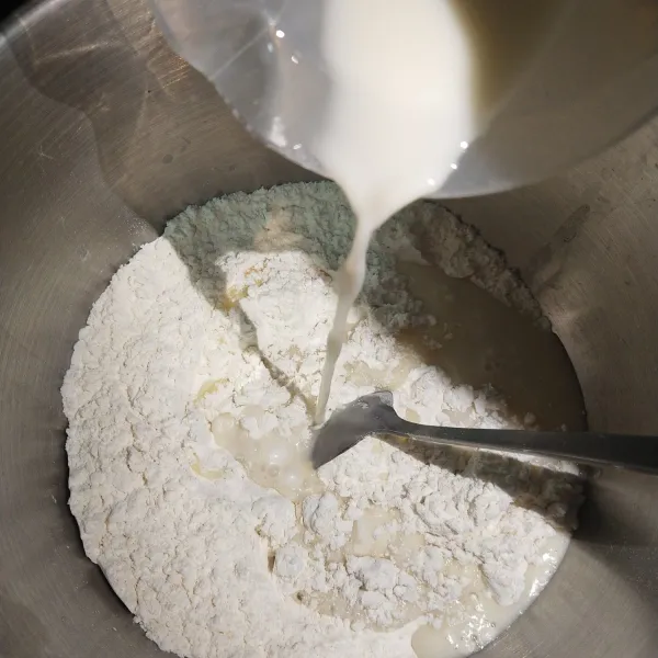 Masukkan tepung terigu, gula pasir, fermipan dan susu cair. Aduk sampai setengah kalis dan elastis.