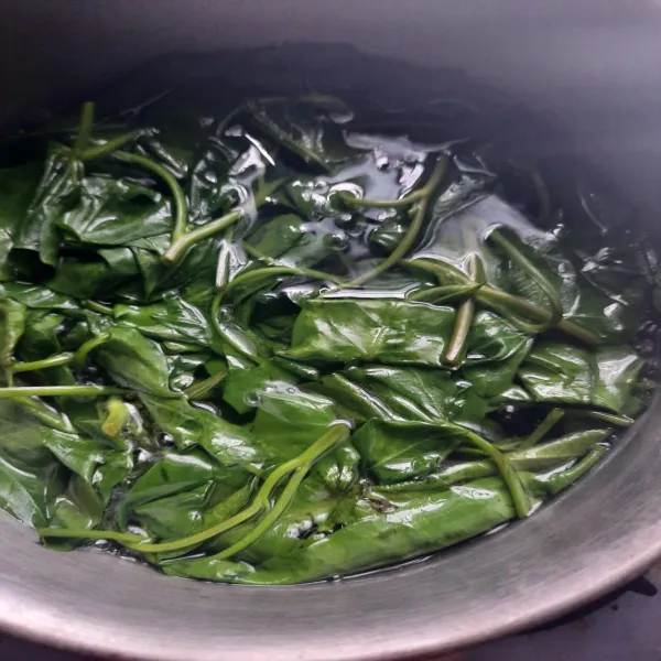 Rebus kangkung yang sudah dibersihkan, tambahkan sedikit garam agar warna sayur tidak pudar.