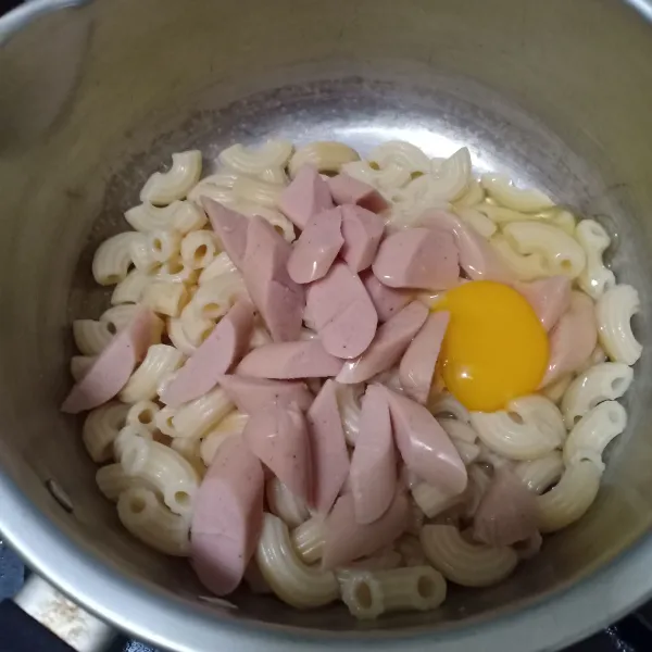 Tiriskan macaroni lalu tambahkan potongan sosis dan telur, aduk rata.