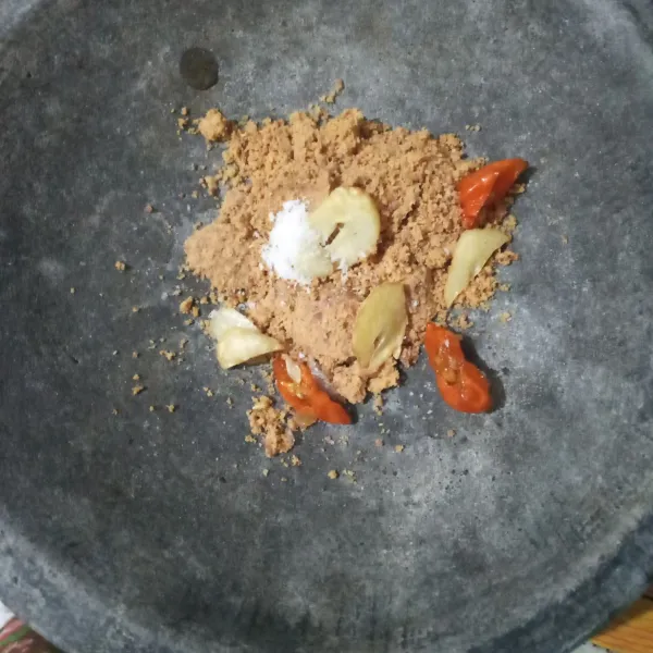 Haluskan kacang tanah, bawang putih, cabai rawit dan garam.
