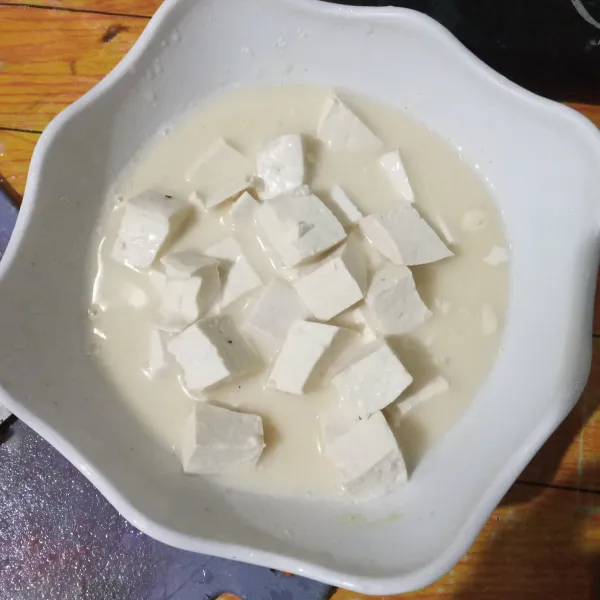 Masukkan potongan tahu ke dalam adonan tepung, rendam selama 15 menit.