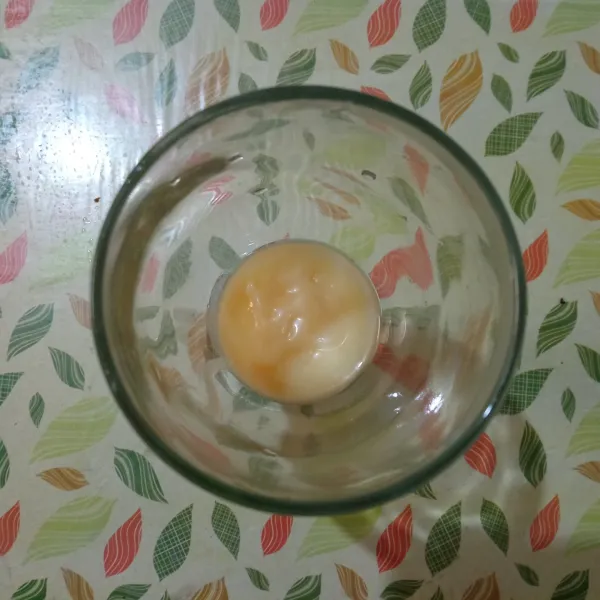 Tuang susu kental manis ke dalam gelas saji.