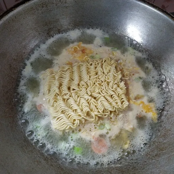 Selanjutnya masukkan mie, sosis dan daun bawang yang sudah dipotong terlebih dahulu.