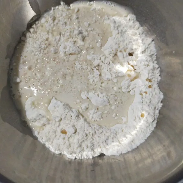 Dalam wadah campur tepung terigu dan garam, lalu aduk rata. Masukkan cairan ragi dan minyak zaitun, lalu aduk rata.