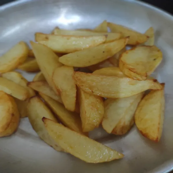 Potong kentang menjadi 8 bagian, kemudian goreng hingga matang, lalu sisihkan.