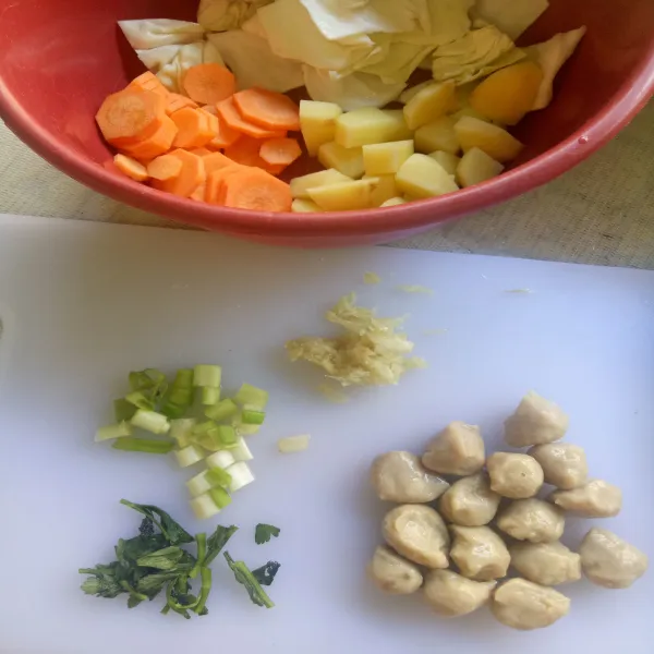 Kupas wortel dan kentang, cuci bersih, lalu potong kecil sesuai selera. Cuci bersih kol lalu potong-potong, iris seledri, daun bawang, dan giling halus bawang putih.