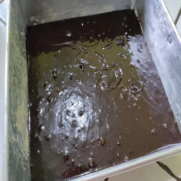 Tuangkan adonan ke dalam loyang yang sudah di balur margarin dan di beri kertas roti.