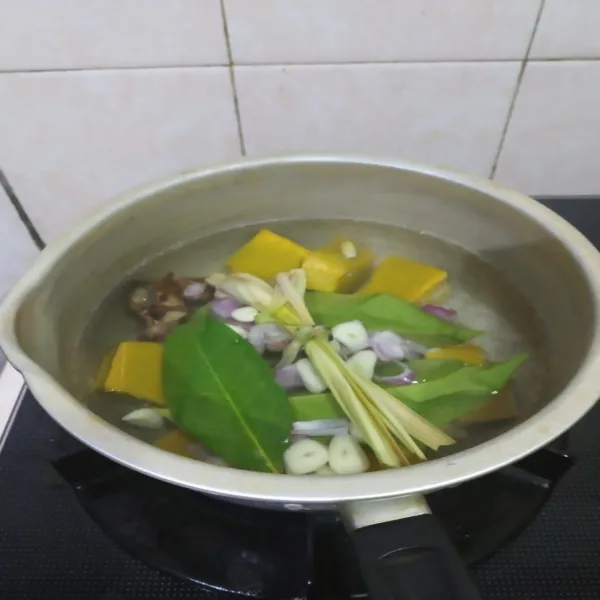 Didihkan air dipanci, masukkan waluh atau labu kuning, irisan bawang merah, bawang putih, serai, lengkuas, daun salam. Masak hingga waluh empuk.