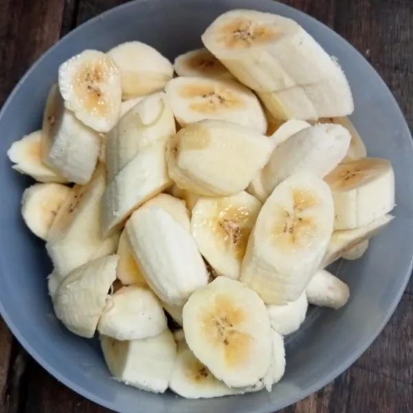 Kupas pisang lalu potong menjadi beberapa bagian.