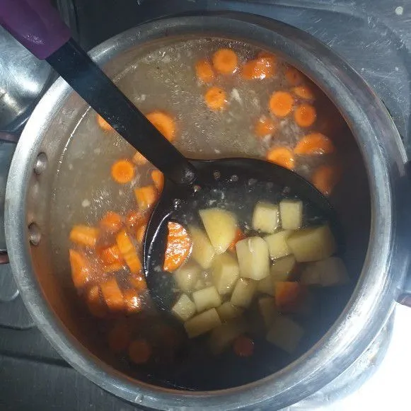 Masukkan wortel dan kentang, masak hingga hampir kemudian masukkan daging.