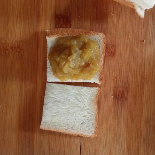 Ambil 1 lembar roti, isi dengan 1 sdm selai pisang. Lalu tutup kembali dengan 1 lembar roti di bagian atasnya.