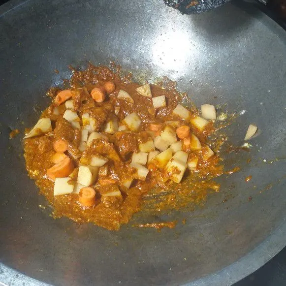 Masukkan wortel, kentang, daging dan air kaldu, aduk merata.