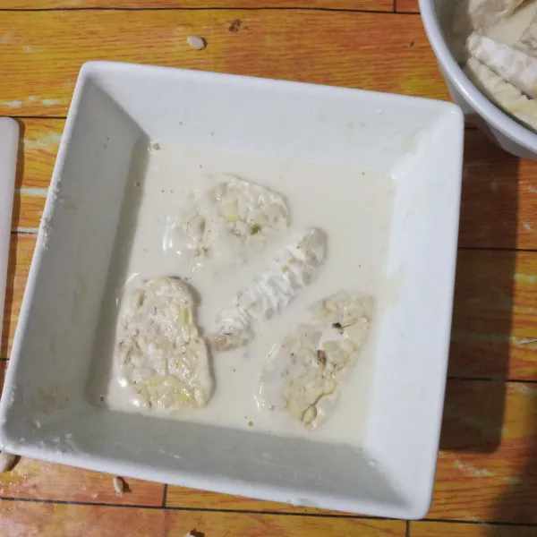 Celupkan tempe ke dalam adonan tepung, biarkan selama 10 menit.
