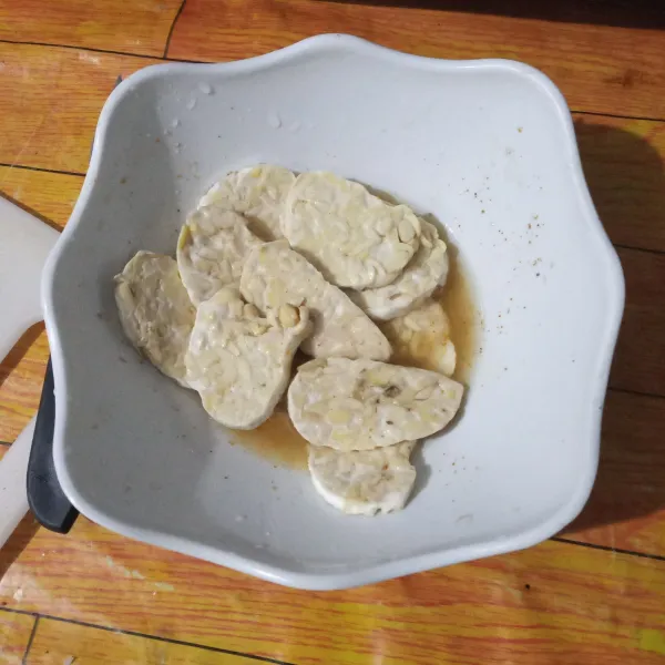 Campurkan semua bahan bumbu marinasi, aduk rata, lalu rendam tempe selama 15 menit.