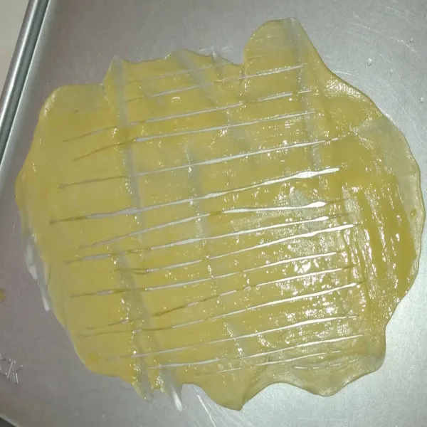 Ambil satu persatu adonan, lalu pipihkan dengan rolling pin, kerat-kerat dengan pisau, jangan sampai putus. Beri olesan margarin cair ke seluruh permukaan adonan.