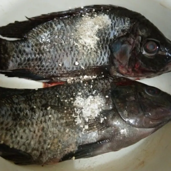 Lumuri ikan dengan bumbu marinasi seperti garam, kaldu jamur, merica bubuk, dan bawang putih bubuk, lalu aduk rata.