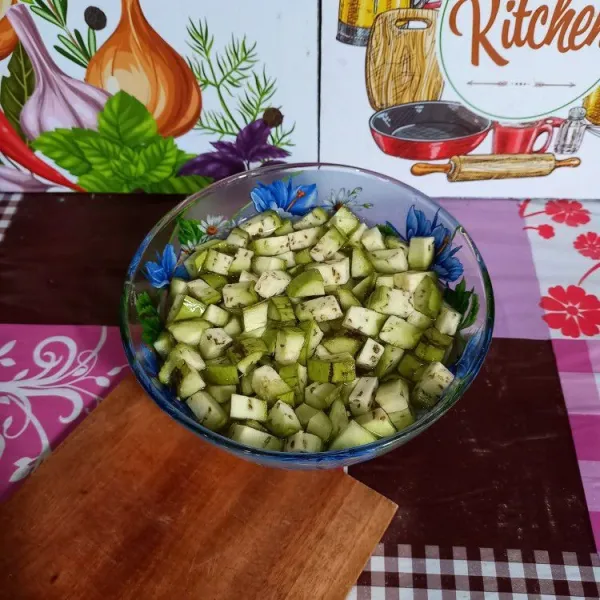 Potong terong kecil-kecil. Rendam dalam air agar tidak menghitam.