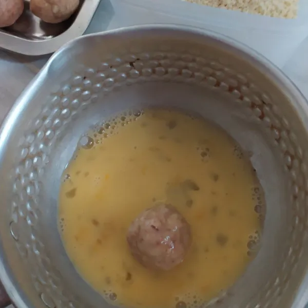 Celup bola kenet ke dalam telur, lalu ke dalam panir. Aduk-aduk supaya menempel dengan rata, biarkan di dalam kulkas selama 15 menit.