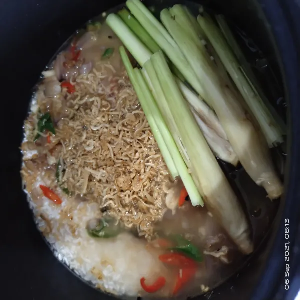 Masukkan tumisan ke dalam rice cooker. Tambahkan sebagian teri ke dalam beras.