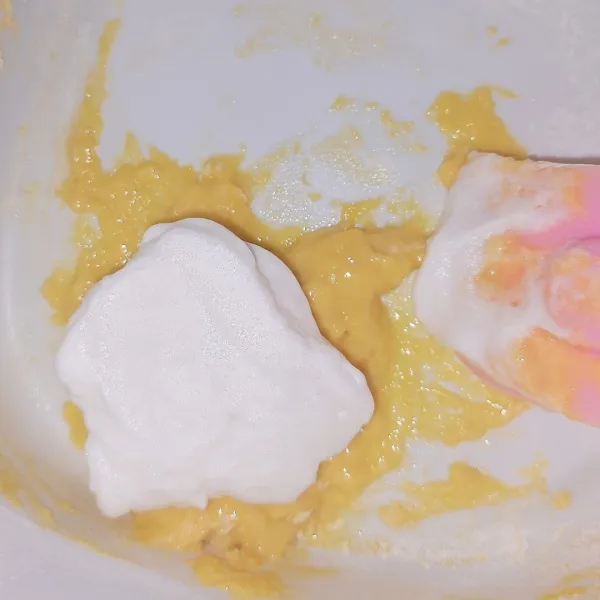 Masukkan sedikit putih telur ke adonan kuning telur.