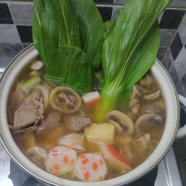 Masukkan tumisan daging dan bumbunya, jamur kancing, pokchoy dan aneka bakso seafood. Tambahkan kaldu jamur, garam dan merica bubuk. Aduk sampai rata sambil koreksi rasa sesuai selera.