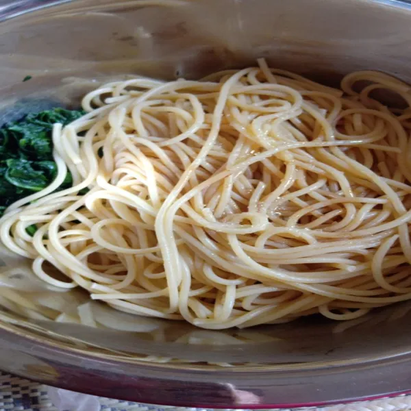 Rebus spaghetti hingga aldante, masukkan dalam 1 wadah dengan bayam. Beri kecap asin, gula pasir dan minyak wijen kembali.