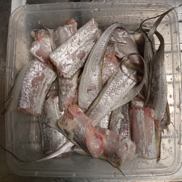 Cuci bersih ikan layur, beri garam, kucuri dengan perasan air jeruk nipis. Diamkan selama 15 menit, lalu bilas kembali.