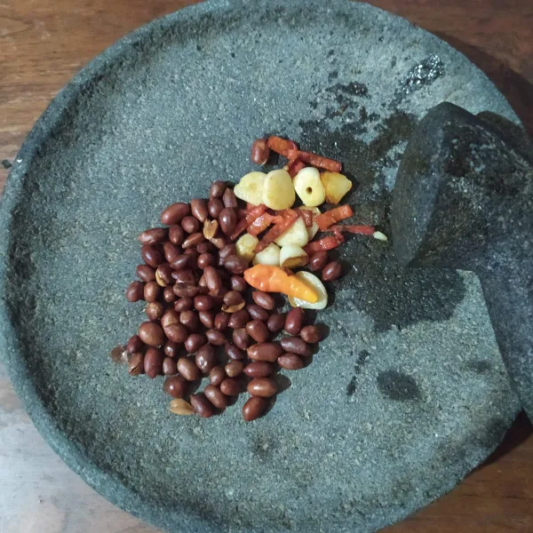 Buat bumbu kacang: kacang digoreng hingga matang, lalu tiriskan (goreng dengan minyak dan api kecil). Goreng sebentar bawang putih dan cabe, haluskan.
