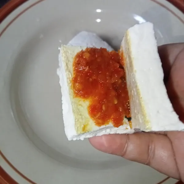 Belah dua tahu tapi tidak sampai putus, lalu masukkan sambal secukupnya.