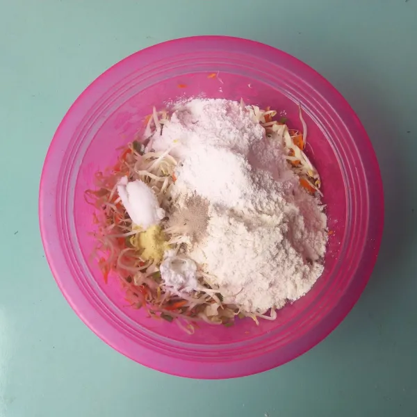 Masukkan tepung terigu, tepung beras, garam, kaldu bubuk, merica bubuk dan baking powder. Lalu tambahkan bawang merah dan bawang putih halus.