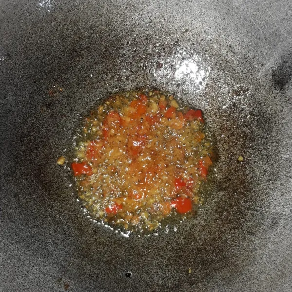 Membuat sambal petis: uleg bawang putih dan cabe rawit lalu tumis hingga harum.