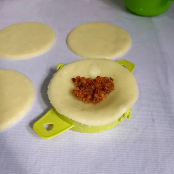 Gunakan alat pencetak pastel atau manual. Isi getuk yang sudah dicetak bulat dengan bumbu kacang.