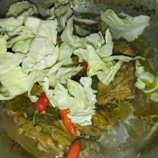 Lalu masukkan potongan kol dan cabai rawit utuh, aduk rata. Masak hingga kol layu dan kuah mendidih kembali.