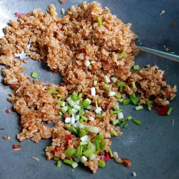 Bila sudah hampir matang, masukkan daun bawang, aduk merata.