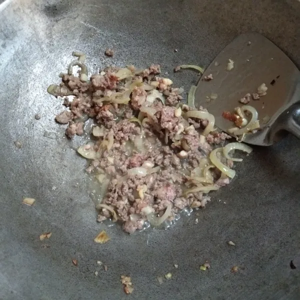 Tumis bawang bombay dan bawang putih hingga harum, lalu masukkan daging cincang. Masak hingga daging cincang matang.