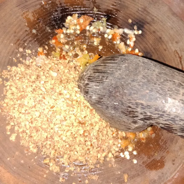 Tambahkan kacang, lalu uleg kembali dan beri secukupnya air.