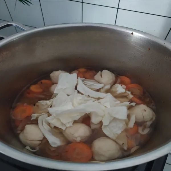 Lalu tambahkan air, masak hingga mendidih kemudian masukkan wortel dan masak setengah matang. Lalu masukkan kol, bakso, garam, kaldu jamur, masak kembali hingga mendidih.