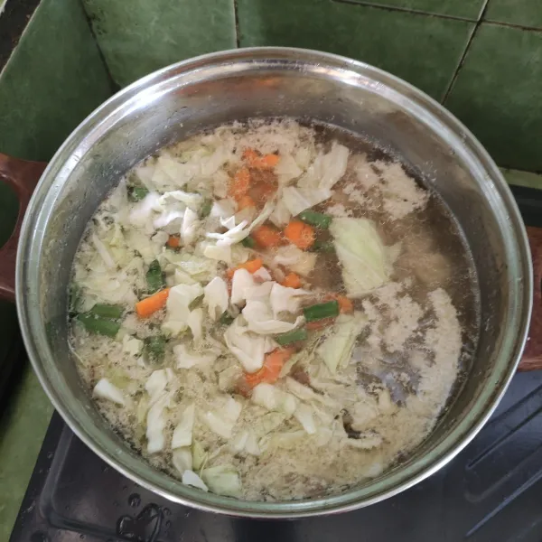 Setelah mendidih kembali campurkan sayur wortel, buncis, kentang, dan kol, lalu aduk merata tunggu sampai sayuran matang.