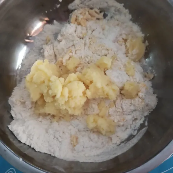 Masukkan kentang, kuning telur, dan air ragi tadi. Campur hingga rata.