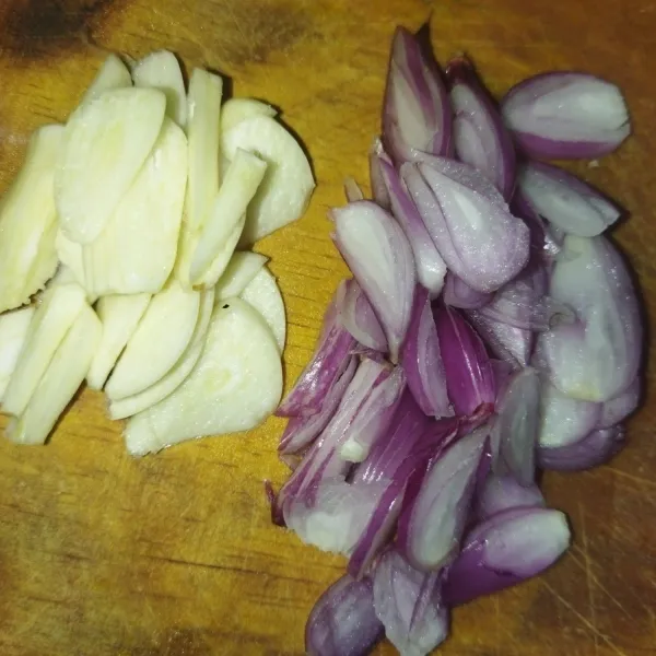 Siapkan bawang merah dan bawang putih, lalu iris tipis.