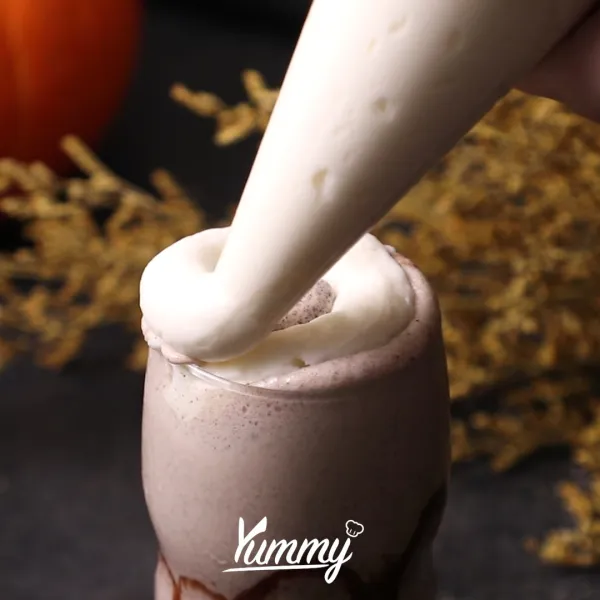 Tuangkan milkshake dan berikan topping whipping cream menyerupai bentuk karakter dari Halloween.