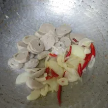 Tumis irisan cabai merah keriting, bawang putih, dan bawang bombay hingga harum. Masukkan irisan bakso, lalu aduk rata.
