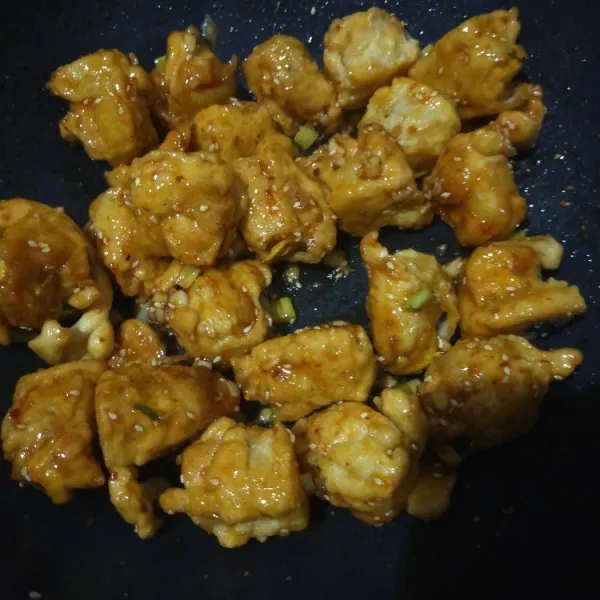 Masukkan tahu goreng ke dalam saus, aduk rata.