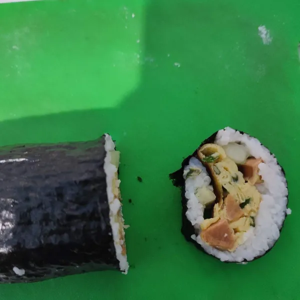 Siapkan pisau bergerigi dan sedikit basah, potong sushi sesuai selera. Sajikan dengan saos favorit.