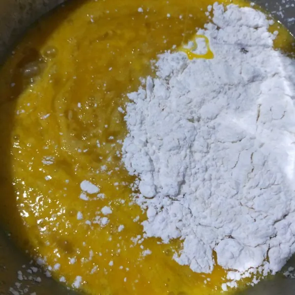Aduk rata tepung terigu dan tepung tapioka. Lalu masukkan ke dalam adonan telur bergantian dengan cairan kuning.