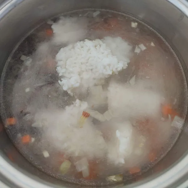 Ketika mulai mendidih, masukkan nasi putih, aduk rata. Masak hingga nasi menjadi lembek atau bertekstur seperti bubur.