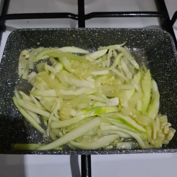 Cuci bersih zucchini, kupas lalu potong memanjang. Masak sebentar dengan sedikit minyak goreng.