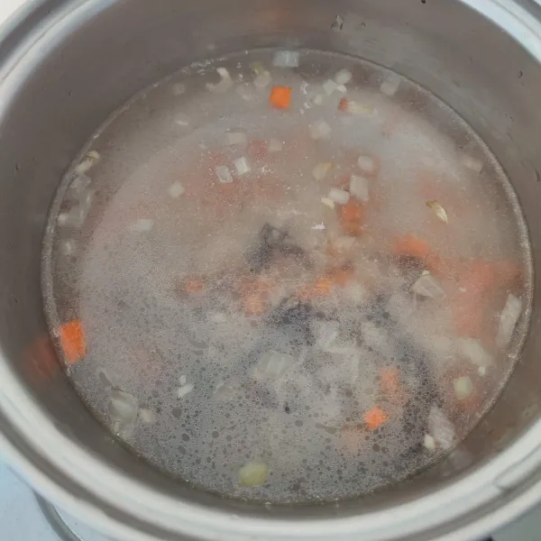 Pindahkan tumisan sayur ke dalam panci. Masukkan air, masak hingga mendidih.