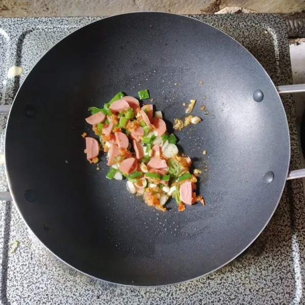 Masukkan irisan sosis dan irisan daun bawang, masak hingga matang